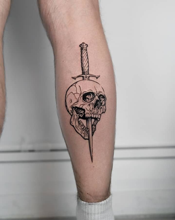 Skull and dagger fine line tattoo on calf