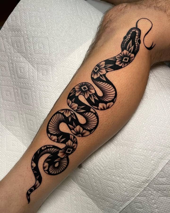 Floral-pattern snake tattoo on calf